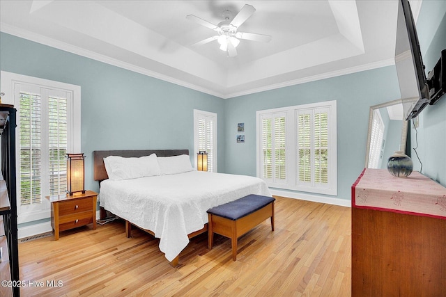 10196 Flint Ct SE, Leland, NC 28451 - bedroom with a raised ceiling, light wood finished floors, crown molding, a ceiling fan, and baseboards