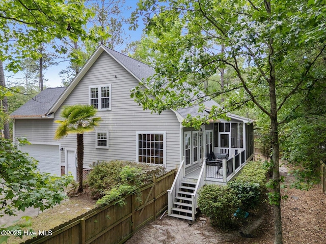 10196 Flint Ct SE, Leland, NC 28451 - back of property with a sunroom, a shingled roof, and a deck