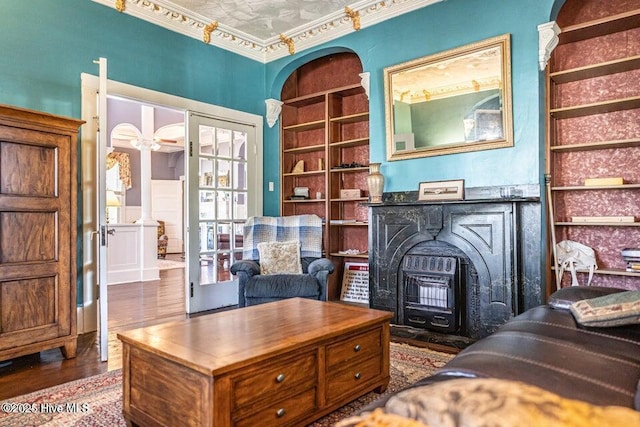 office space with built in features, wood finished floors, and ornamental molding
