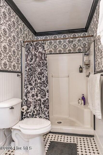 bathroom with wallpapered walls, crown molding, toilet, and a shower