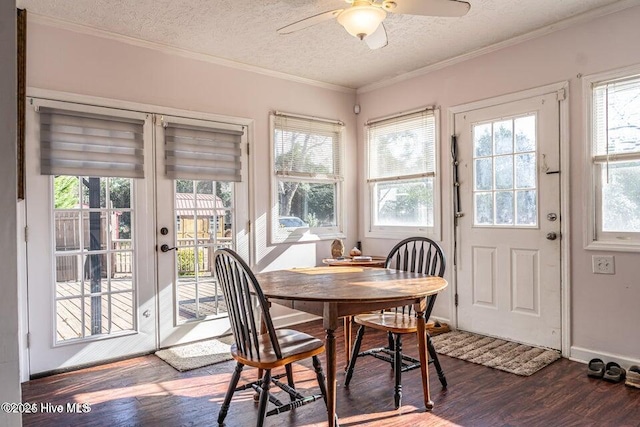 dining space with dark wood-style flooring, ceiling fan, a textured ceiling, crown molding, and baseboards