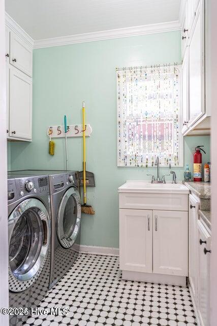 washroom featuring washer and dryer, cabinet space, crown molding, and baseboards