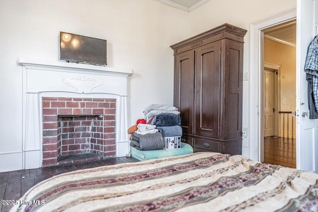 bedroom with crown molding and a fireplace