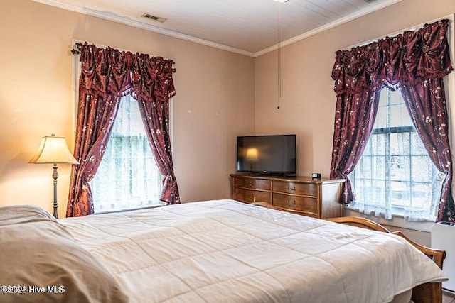 bedroom featuring multiple windows and crown molding