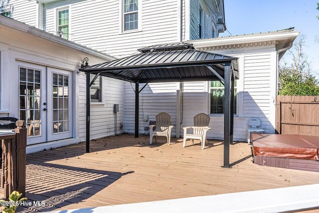 wooden terrace with a gazebo, french doors, and a covered hot tub
