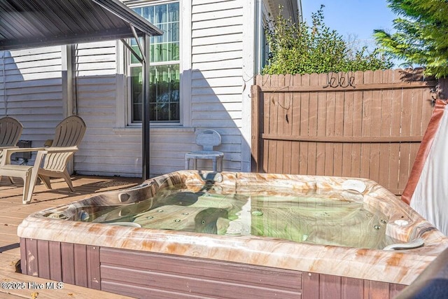wooden deck with a hot tub