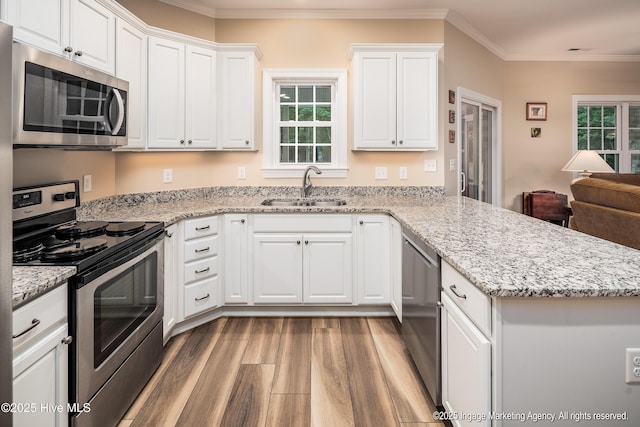 118 Hill Creek Rd, Blounts Creek, NC 27814 - kitchen with appliances with stainless steel finishes, a sink, wood finished floors, a peninsula, and white cabinetry