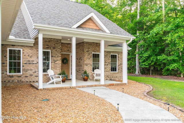 118 Hill Creek Rd, Blounts Creek, NC 27814 - property entrance with a shingled roof, a porch, brick siding, and a lawn