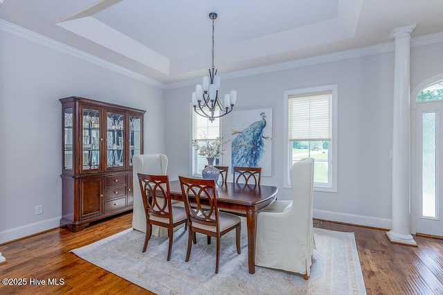 4010 Sienna Trl, New Bern, NC 28562 - dining room with ornate columns, a raised ceiling, a chandelier, wood finished floors, and baseboards