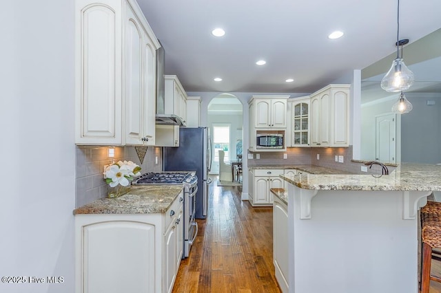 4010 Sienna Trl, New Bern, NC 28562 - kitchen featuring stainless steel appliances, a breakfast bar, arched walkways, tasteful backsplash, and recessed lighting