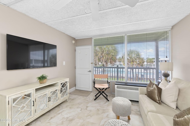 1918 W Fort Macon Rd Unit 205Bogue, Shores Condominium, Atlantic Beach, NC 28512 - living room featuring light marble finish flooring, a textured ceiling, baseboards, ceiling fan, and expansive windows