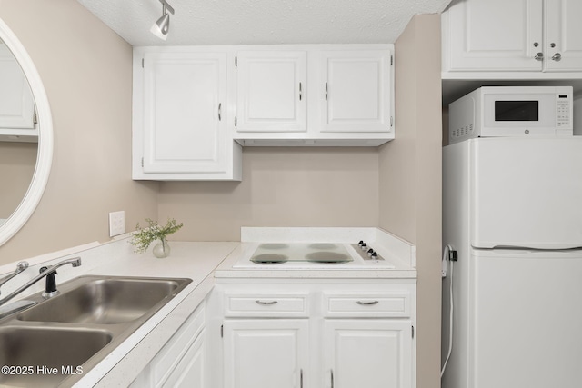 1918 W Fort Macon Rd Unit 205Bogue, Shores Condominium, Atlantic Beach, NC 28512 - kitchen with white appliances, a sink, white cabinets, light countertops, and a textured ceiling