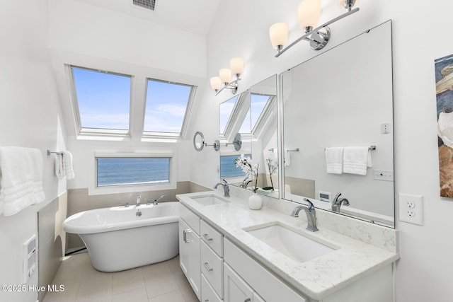 301 Salter Path Rd Unit 72Genesis, Pine Knoll Shores, NC 28512 - bathroom with a skylight, double vanity, a freestanding bath, tile patterned flooring, and wainscoting