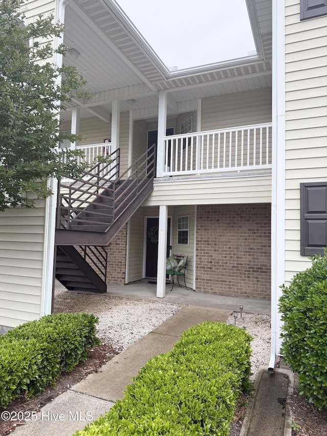 view of side of property featuring stairway and brick siding