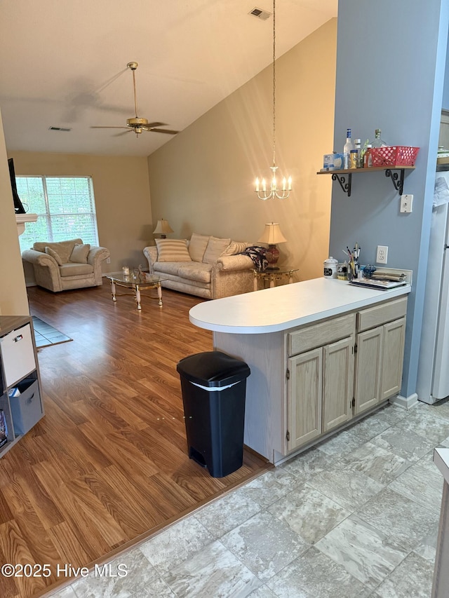 kitchen featuring ceiling fan, a chandelier, pendant lighting, light countertops, and open floor plan