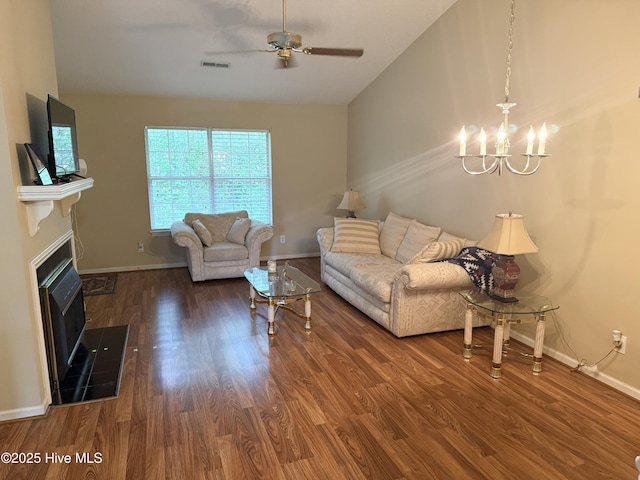 living area with a ceiling fan, a chandelier, wood finished floors, and baseboards