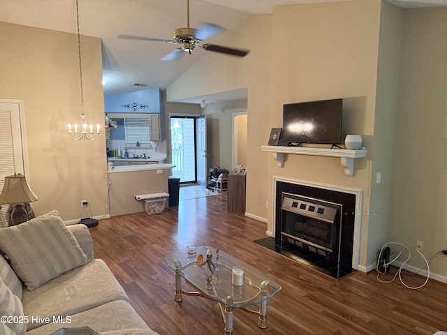 living room with a ceiling fan, vaulted ceiling, a fireplace with flush hearth, wood finished floors, and baseboards