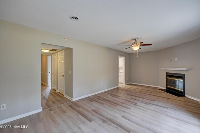 4941 Marlin Ct, Wilmington, NC 28403 - unfurnished living room featuring wood finished floors, a fireplace with flush hearth, ceiling fan, and baseboards