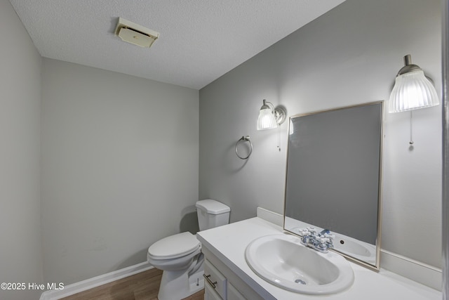4941 Marlin Ct, Wilmington, NC 28403 - half bathroom featuring wood finished floors, toilet, vanity, a textured ceiling, and baseboards