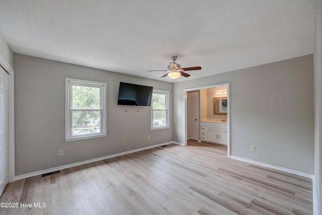 4941 Marlin Ct, Wilmington, NC 28403 - unfurnished bedroom with light wood finished floors, ensuite bathroom, baseboards, a textured ceiling, and ceiling fan