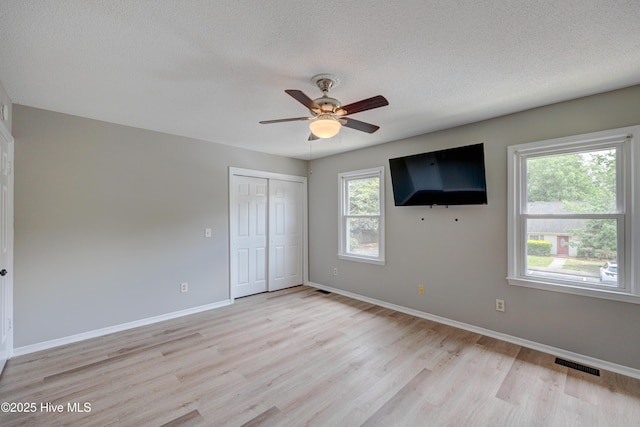 4941 Marlin Ct, Wilmington, NC 28403 - unfurnished bedroom with light wood finished floors, a textured ceiling, baseboards, a closet, and a ceiling fan