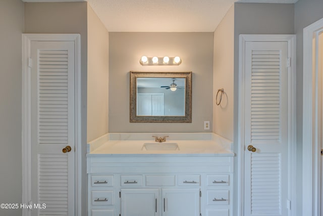 4941 Marlin Ct, Wilmington, NC 28403 - bathroom featuring a closet, vanity, ceiling fan, and a textured ceiling
