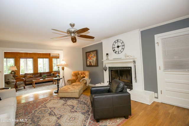 7 Saddle Pl, Pinehurst, NC 28374 - living room featuring a ceiling fan, light wood-style floors, a fireplace, and ornamental molding