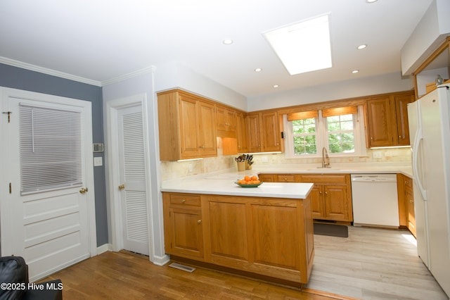 7 Saddle Pl, Pinehurst, NC 28374 - kitchen with white appliances, backsplash, a skylight, light countertops, and recessed lighting