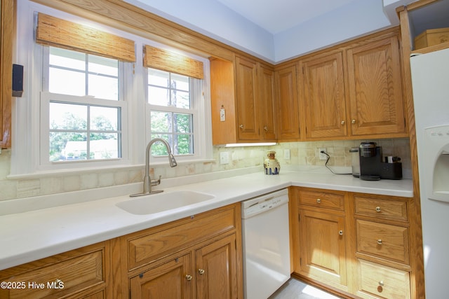 7 Saddle Pl, Pinehurst, NC 28374 - kitchen with dishwasher, brown cabinetry, light countertops, and tasteful backsplash