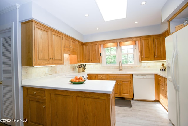 7 Saddle Pl, Pinehurst, NC 28374 - kitchen with white appliances, a peninsula, tasteful backsplash, a skylight, and light countertops