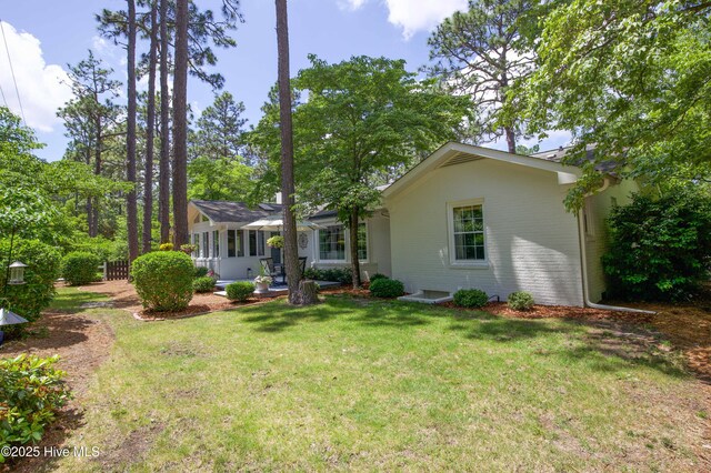 7 Saddle Pl, Pinehurst, NC 28374 - back of house with a sunroom and a lawn