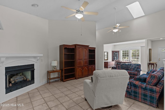 3665 Willow Lake Dr SE, Southport, NC 28461 - living room featuring high vaulted ceiling, light tile patterned floors, a ceiling fan, a fireplace, and a skylight