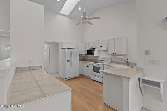 3665 Willow Lake Dr SE, Southport, NC 28461 - kitchen with white appliances, high vaulted ceiling, a sink, ceiling fan, and a skylight