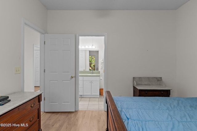3665 Willow Lake Dr SE, Southport, NC 28461 - bedroom featuring light wood-style floors, ensuite bathroom, and a sink