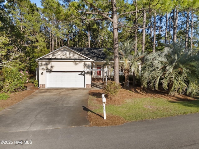 3665 Willow Lake Dr SE, Southport, NC 28461 - view of front of home featuring a garage, concrete driveway, and view of wooded area