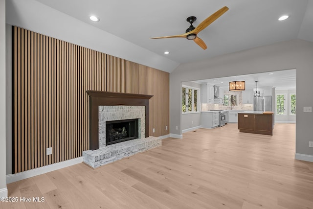 101 Marshview Rd, Hampstead, NC 28443 - unfurnished living room with vaulted ceiling, ceiling fan, light wood-style floors, a brick fireplace, and baseboards