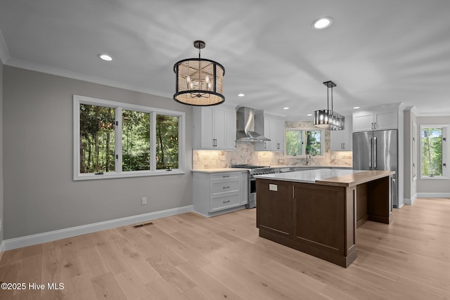 101 Marshview Rd, Hampstead, NC 28443 - kitchen featuring wall chimney range hood, appliances with stainless steel finishes, light countertops, a chandelier, and backsplash