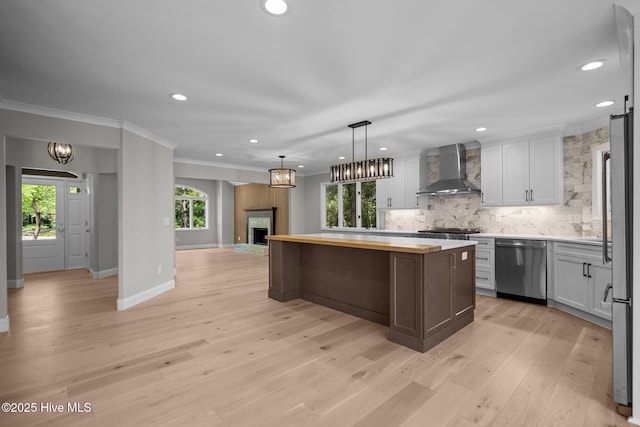 101 Marshview Rd, Hampstead, NC 28443 - kitchen featuring wall chimney range hood, appliances with stainless steel finishes, recessed lighting, backsplash, and a fireplace