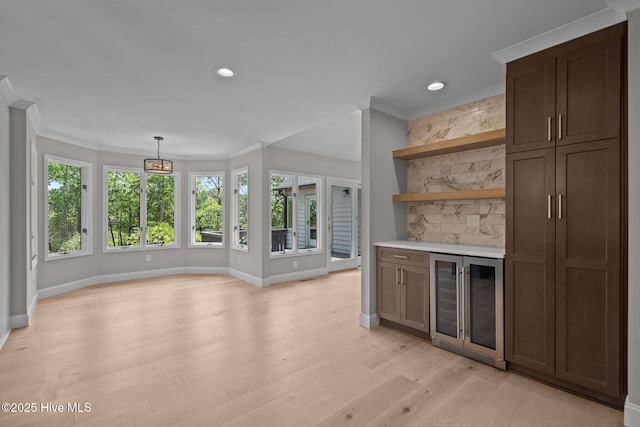101 Marshview Rd, Hampstead, NC 28443 - indoor dry bar featuring beverage cooler, crown molding, healthy amount of natural light, light wood-type flooring, and baseboards