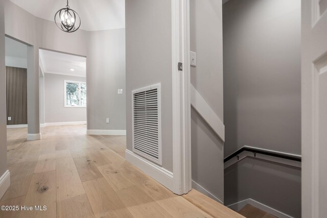 101 Marshview Rd, Hampstead, NC 28443 - hall featuring a chandelier, light wood-style flooring, and baseboards
