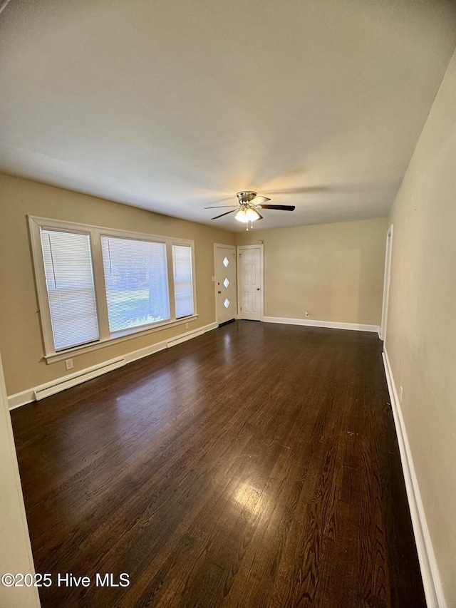 1305 Westwood Ave W, Wilson, NC 27893 - spare room featuring dark wood-style flooring, ceiling fan, baseboards, and a baseboard heating unit