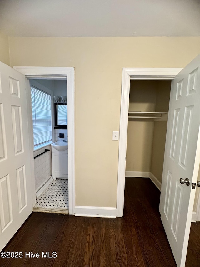 1305 Westwood Ave W, Wilson, NC 27893 - unfurnished bedroom featuring wood finished floors, a closet, a sink, and baseboards
