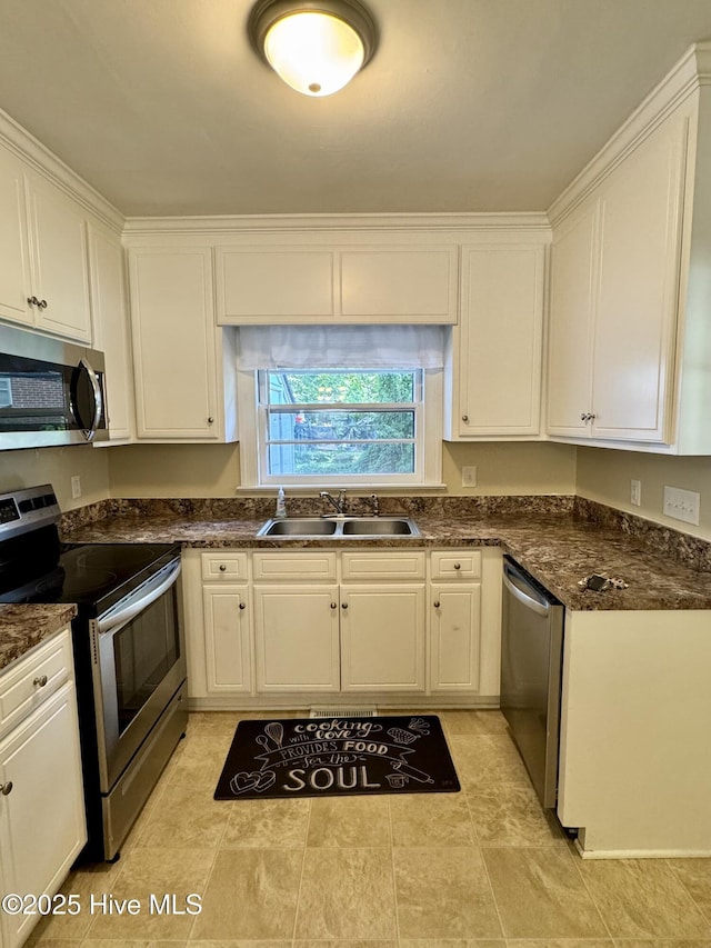 1305 Westwood Ave W, Wilson, NC 27893 - kitchen with appliances with stainless steel finishes, a sink, white cabinets, and dark countertops