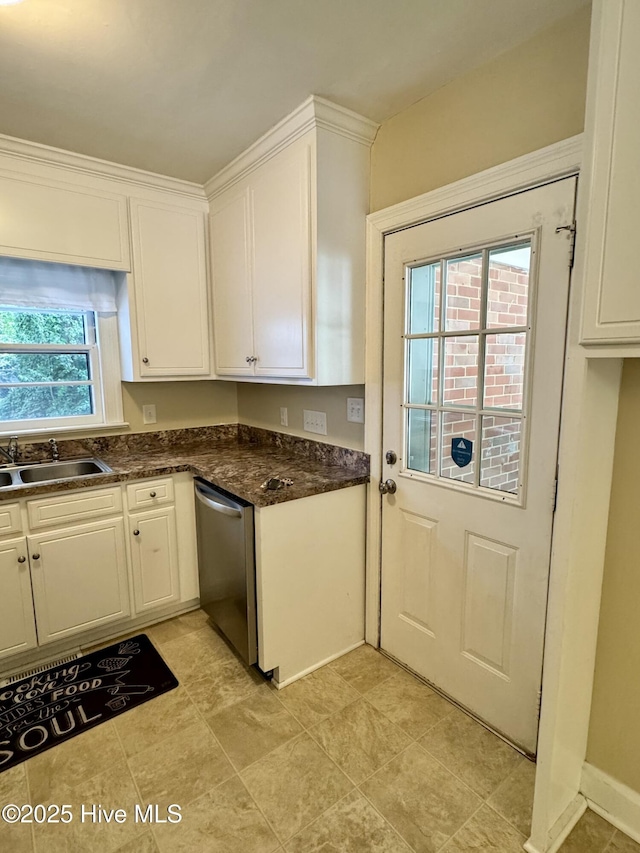 1305 Westwood Ave W, Wilson, NC 27893 - kitchen with stainless steel dishwasher, a sink, white cabinets, and dark countertops