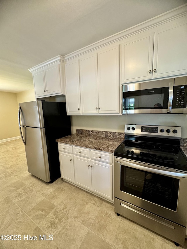 1305 Westwood Ave W, Wilson, NC 27893 - kitchen featuring appliances with stainless steel finishes, white cabinetry, baseboards, and dark stone countertops