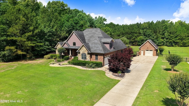 207 Hooping Crane Ln, Goldsboro, NC 27530 - view of front of home with a forest view, an outdoor structure, stone siding, brick siding, and a detached garage
