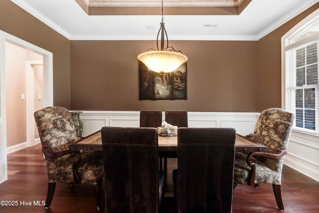 207 Hooping Crane Ln, Goldsboro, NC 27530 - dining area featuring a raised ceiling, wood finished floors, crown molding, and a decorative wall