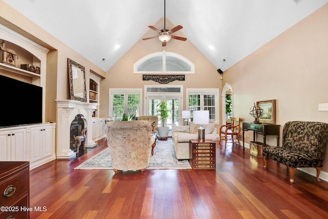 207 Hooping Crane Ln, Goldsboro, NC 27530 - living area featuring ceiling fan, dark wood finished floors, high vaulted ceiling, a glass covered fireplace, and built in features