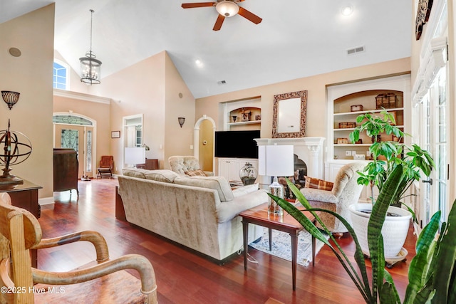 207 Hooping Crane Ln, Goldsboro, NC 27530 - living room featuring built in features, ceiling fan, a fireplace, dark wood finished floors, and high vaulted ceiling