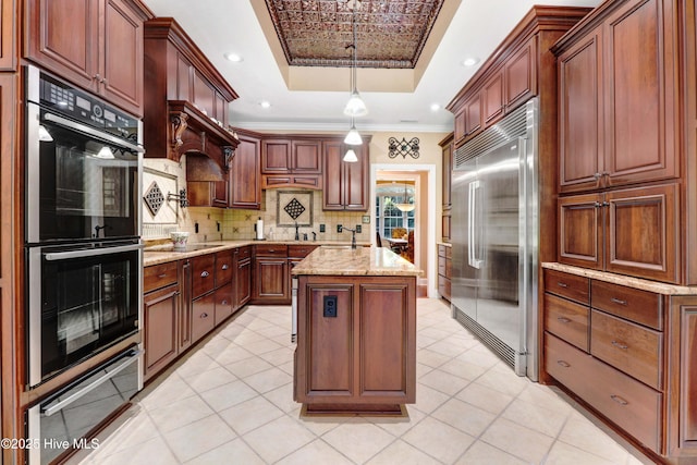 207 Hooping Crane Ln, Goldsboro, NC 27530 - kitchen with stainless steel built in fridge, double oven, a raised ceiling, ornamental molding, and a kitchen island with sink